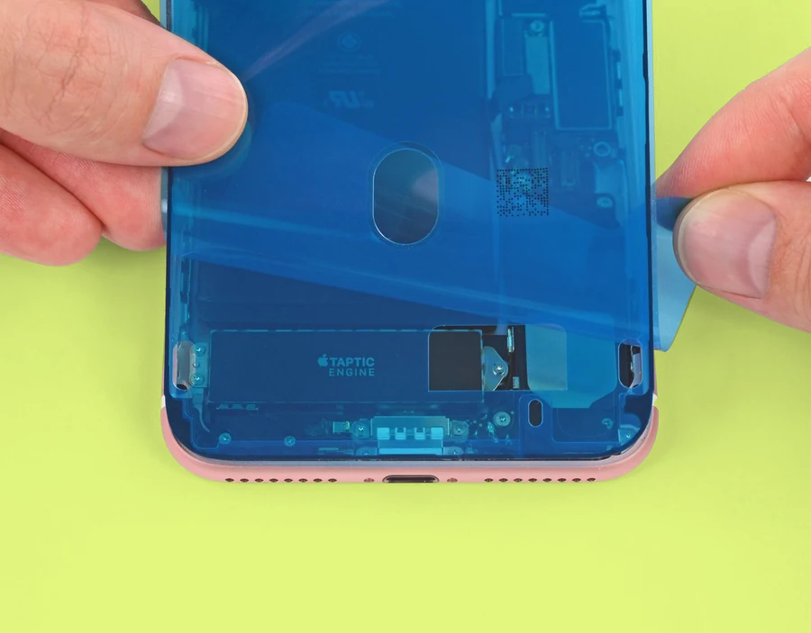Someone attaching replacement adhesive to an iPhone frame